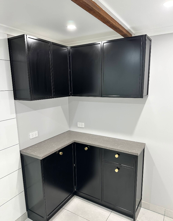 Matte black cabinetry with brass hardware