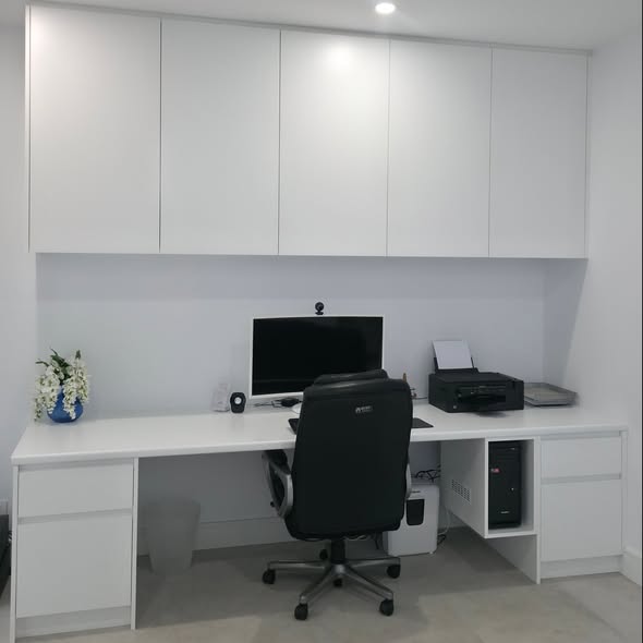 Built-in white home office with desk and overhead cabinets